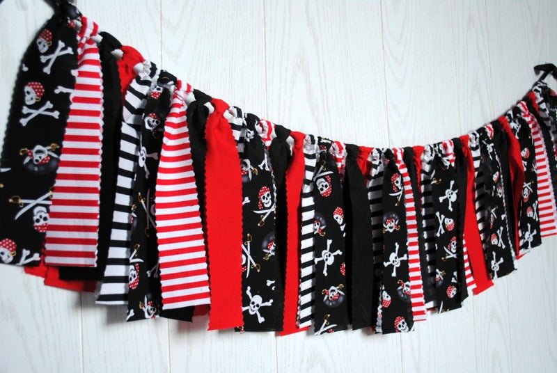 Festive pirate-themed fabric bunting displayed on a wall for a party