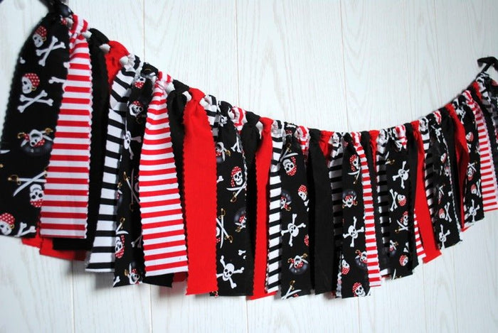 Festive pirate-themed fabric bunting displayed on a wall for a party
