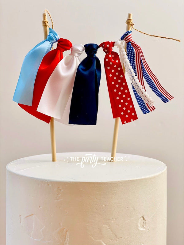 http://shop.thepartyteacher.com/cdn/shop/products/usa-ribbon-cake-topper-854851_600x.jpg?v=1671196993